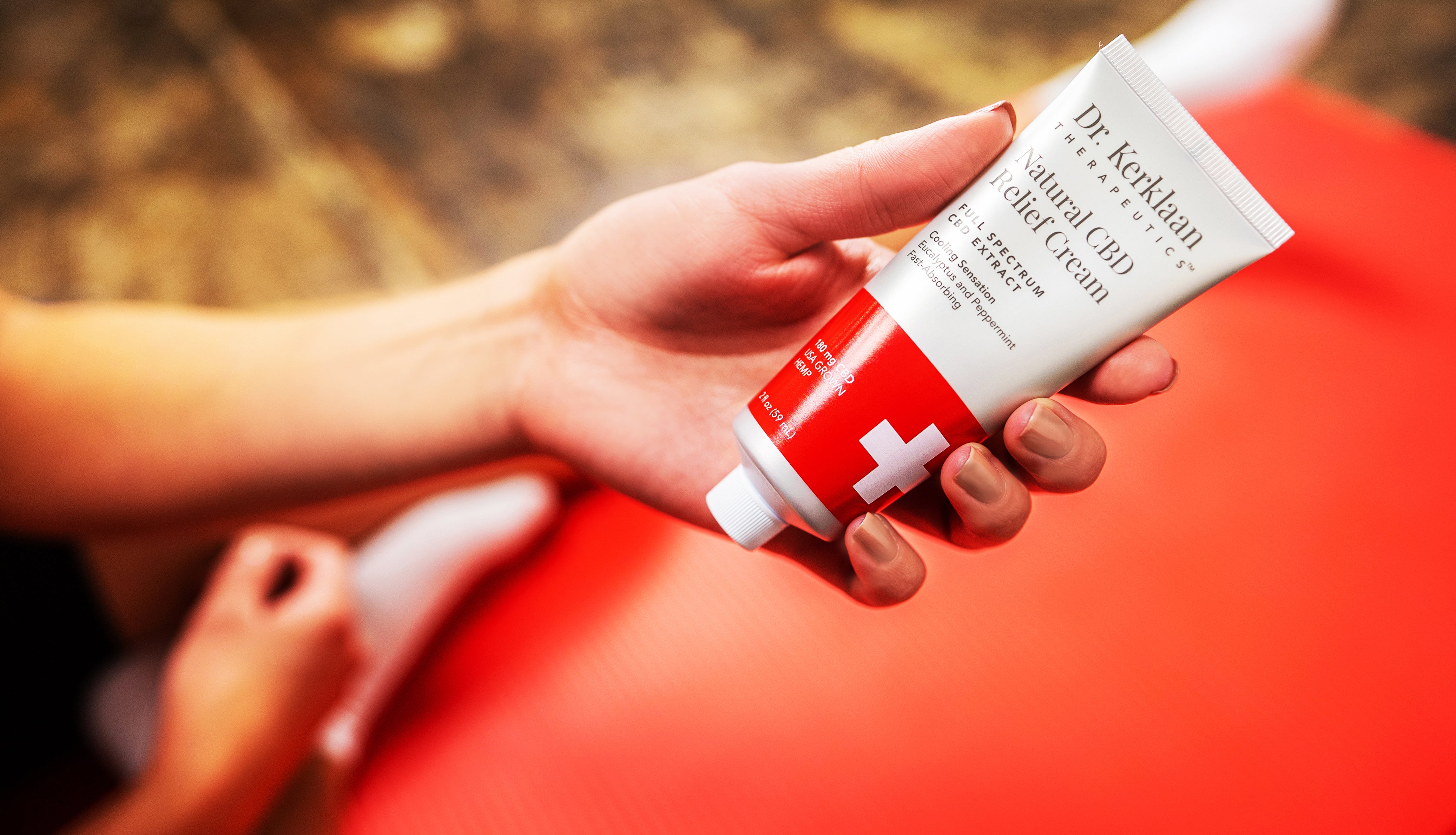 Natural CBD Relief Cream held in woman's hand ready to apply for CBD relief.