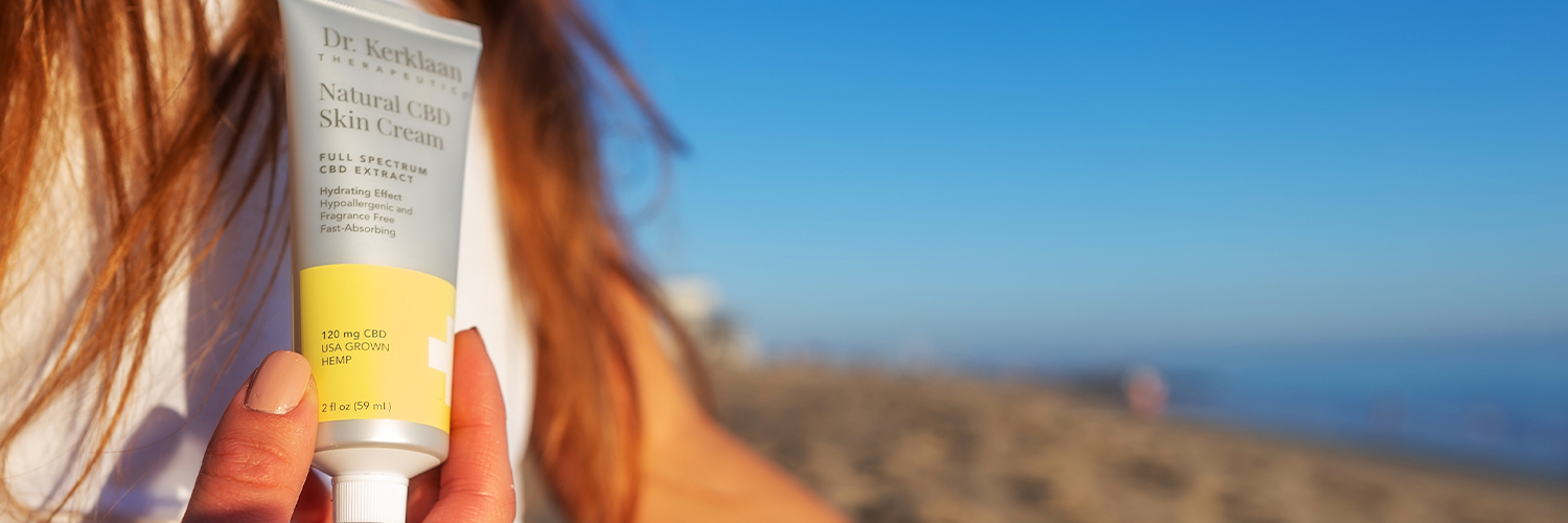 Skin Cream held in the sun on the beach.
