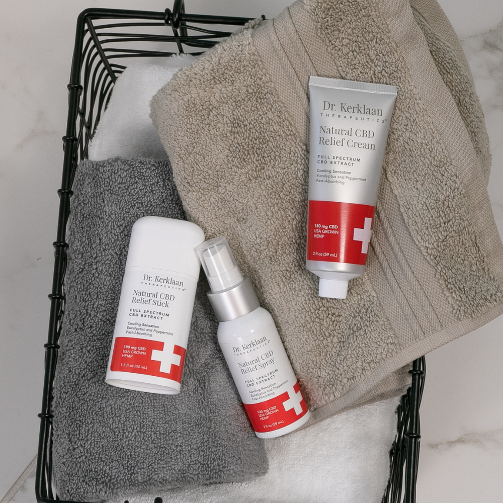 Dr. Kerklaan Natural CBD Relief Kit placed on soft, neutral-toned towels in a bathroom setting, perfect for post-shower relaxation.