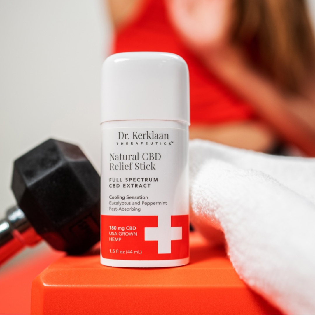 Dr. Kerklaan Natural CBD Relief Stick placed on a gym bench with a dumbbell and towel, highlighting its fast-acting, cooling relief for sore muscles and joint discomfort.