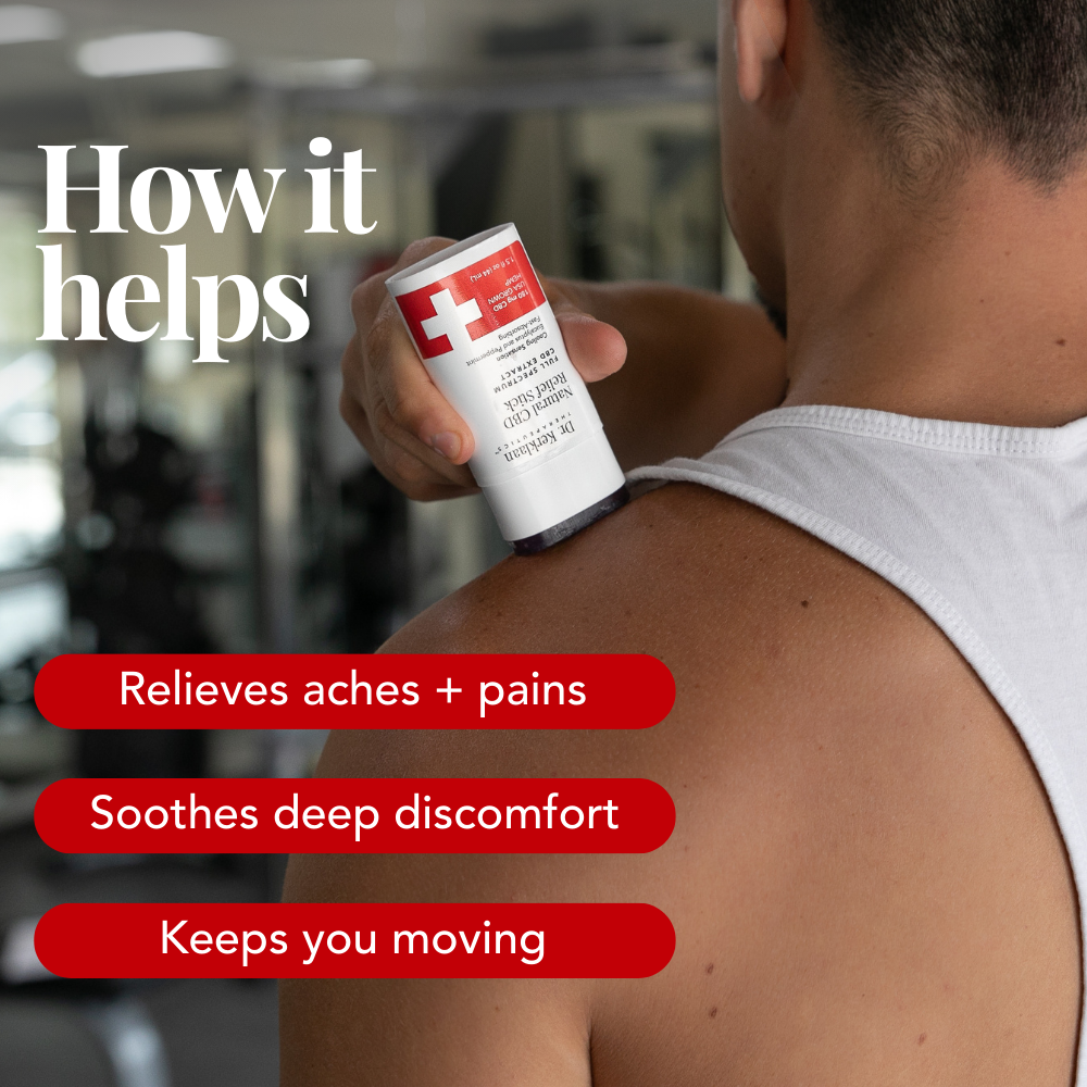 Man applying the CBD Relief Stick to his shoulder in the gym, demonstrating targeted relief for sore muscles.